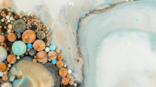 Colorful paint in bubbles organically moves in the liquid