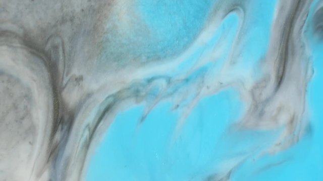 Colorful paint with silver particles organically moves in the liquid