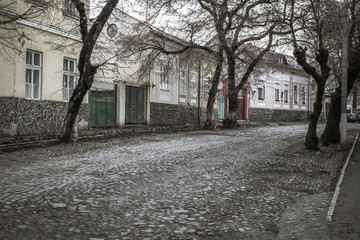 Street in the old town. Travel in Europe. Cityscape. Pavement on the street. Low-rise buildings along the road. Facade of old residential buildings. The architecture of old Europe.