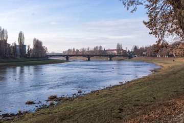 River landscape in spring or autumn. The bend of a shallow river. Trees on the bank along the river. Picturesque autumn landscape. Stream of the river in the city. Beautiful nature.