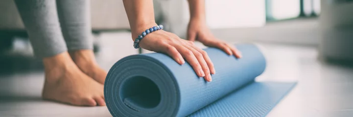 Stickers pour porte École de yoga Yoga à la maison mode de vie actif femme roulant un tapis d& 39 exercice dans le salon pour fond de bannière de yoga méditation matinale.