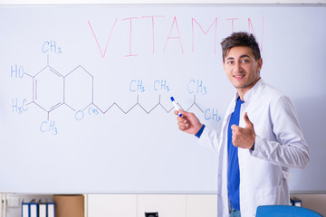 Young chemist standing in front of the whiteboard 