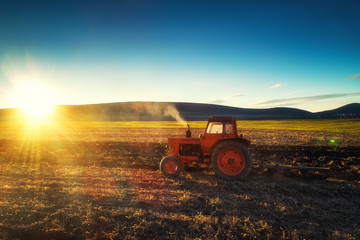 Tractor cultivating field at spring