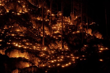 Small fires in a rocky hill with trees during a light celebration in the Frankonian Alb, Southern Germany.