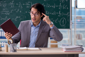 Young handsome math teacher in classroom 
