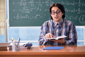 Young funny math teacher in front of chalkboard 
