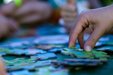 Dziecięca dłoń układające puzzle - obrazy, fototapety, plakaty
