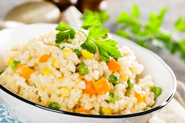 Bulgur wheat boiled with carrot, green peas and corn, healthy vegan diet