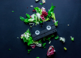 Cabbage and vintage VHS cassette on dark background