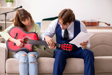 Young woman during music lesson with male teacher