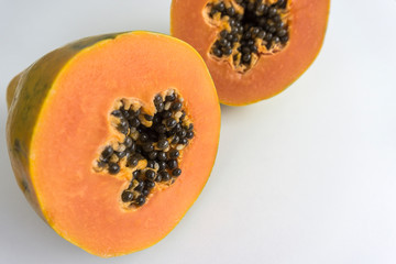 Papaya cut in half in close up on white background