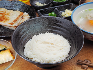 A bowl of thin noodles on wooden table  