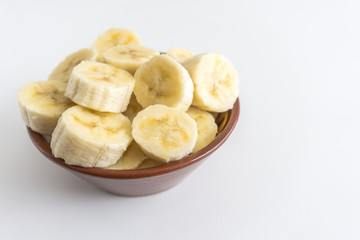 Bowl with banana slices on white background