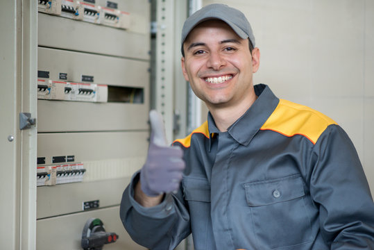 Portrait of a cheerful electrician giving thumbs up