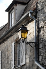 Fototapeta na wymiar Ville de Senlis, une façade du centre historique de la ville et vieux lampadaire, département de l'Oise, France