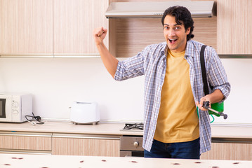 Professional contractor doing pest control at kitchen