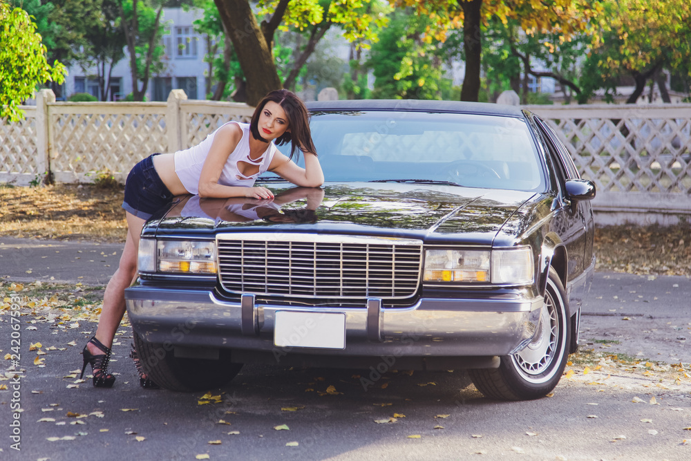 Canvas Prints young beautiful girl in a t-shirt and shorts near the car