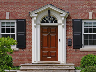 Fototapeta na wymiar elegant dark wood door of brick house