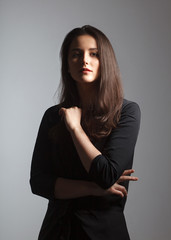 artistic moody portrait of young woman on studio background