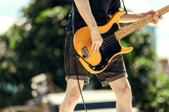 Close-up of bassist playing at an outdoor show