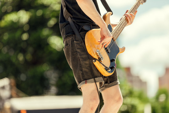 Close-up of bassist playing at an outdoor show