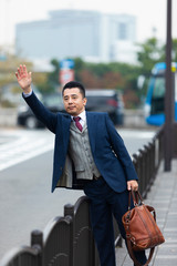 タクシーを呼ぶビジネスマン