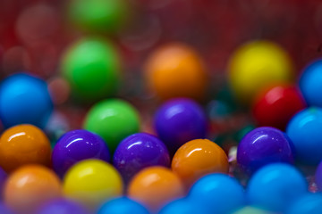 Multicolored round candy balls with out of focus background.