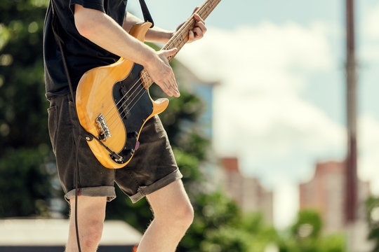 Close-up of bassist playing at an outdoor show