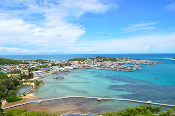 Fototapeta premium The small haven of Thailand village with a turquoise sea and houses of the coast