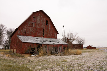 Fototapeta premium Old red barn in the rural countryside after a morning snow dusting. Norway, Illinois, USA