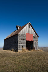 Fototapeta na wymiar Old wooden barn in the rural open farmland. Illinois, USA