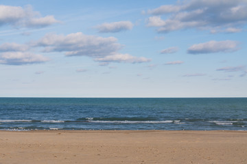 Lake Michigan on a beautiful Autumn morning with blue skies and clouds above.  Indiana Dunes, Indiana, USA