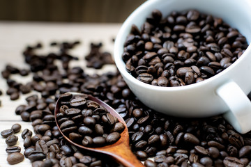 Coffee beans are placed in containers and spread on the background of wood grain.