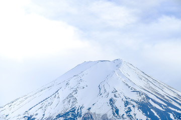 Fuji Mountain on top ,white isolated clouds sky background, blue mountain snow on top, close up focus Fuji mountain in Japan.