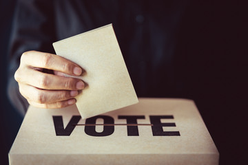 brown paper insert in vote box, democracy concept, retro tone