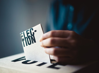 election card insert in vote box, democracy concept, retro tone