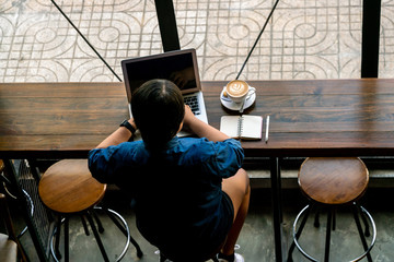 Young girl working on laptop in the coffee