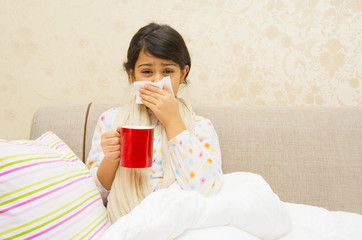 Sick little girl at home on the sofa