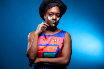 african american woman with tribal face paint and traditional head wrap