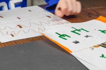 Boy coloring at table with color pencils.