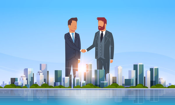two businessmen shaking hands partners successful agreement business deal hand shake concept over big modern city building skyscraper cityscape skyline flat horizontal