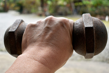 One dark brown weight lifting steel in the athlete's strong hand