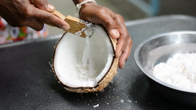 Woman use grater and grate coconut prepare for making Thai dessert