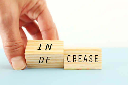 person hand flipping wooden cubes so that it will be written increase instead of decrease. business development and positive thinking concept.