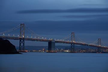 Fototapeta na wymiar The San Francisco - Oakland Bay Bridge with San Francisco in the background during evening blue hour.