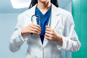 Doctor woman in white coat holding stethoscope