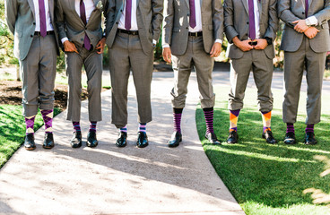 men in suits pant legs up showing purple and white socks