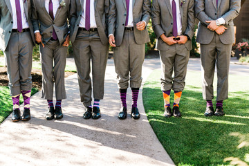 men in suits pant legs up showing purple and white socks