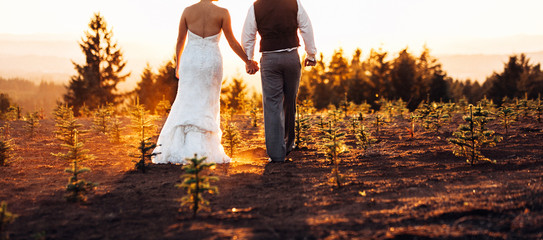 bride and groom at fiery sunset after wedding