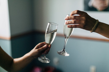 two glasses clinking together after a toast and cheers